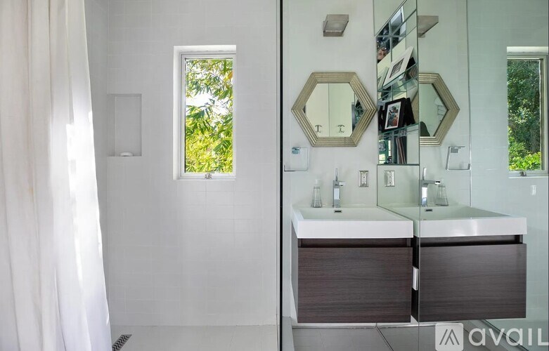 A bathroom with a large mirror and a window.