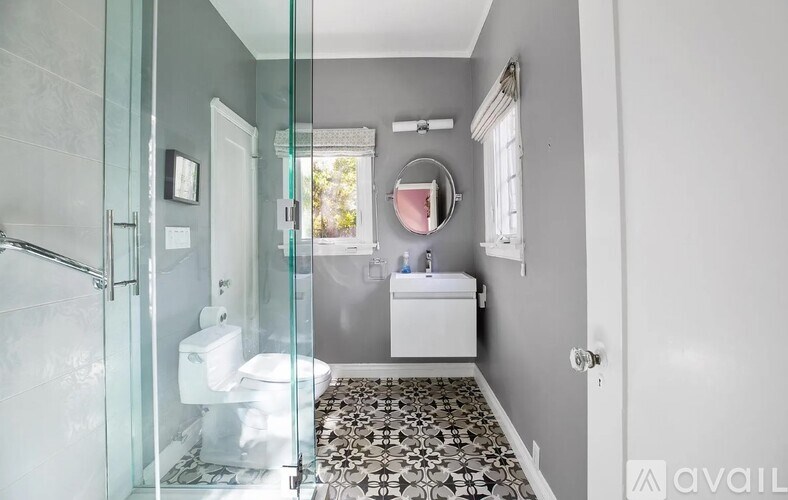 A bathroom with a glass shower stall and a white toilet.