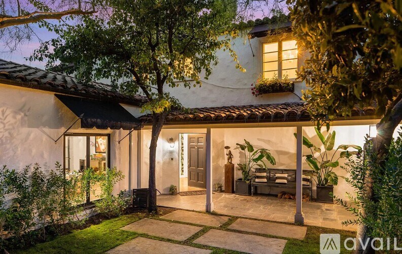A house with a patio and a tree in front of it.