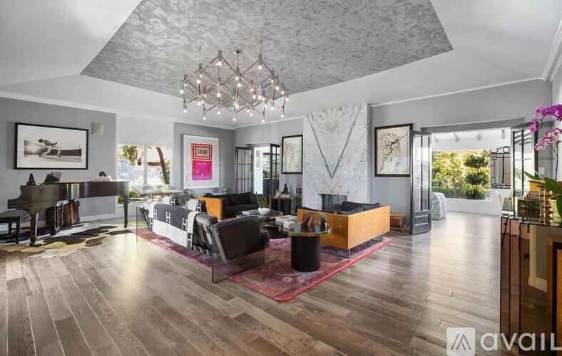 A modern living room with a piano and a large rug.