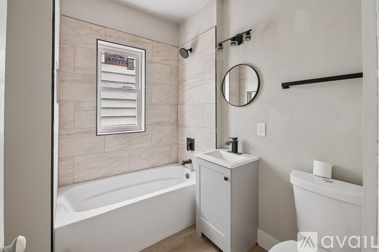 A bathroom with a tub, toilet, and sink.