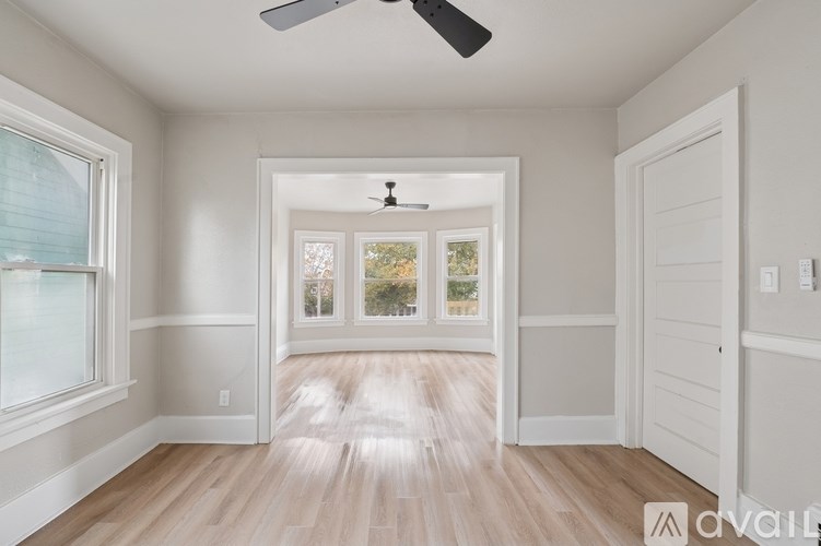 A room with a ceiling fan and a door leading to a balcony.