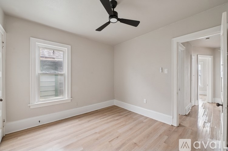 A room with a ceiling fan and a window.