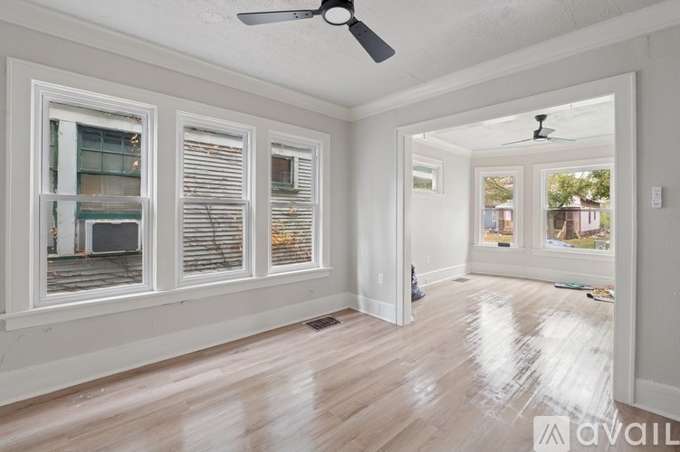 A room with a fan and a window with blinds.