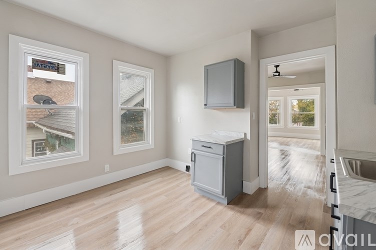 A room with a grey cabinet and a window showing a house.