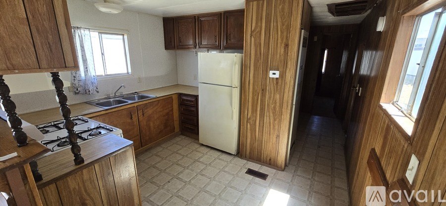 A kitchen with wooden cabinets and a white refrigerator.