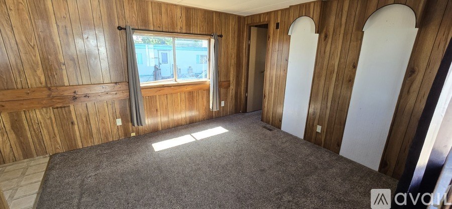 A room with wooden walls and a carpeted floor.