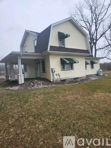 A house with a brown roof and a white fence is shown.