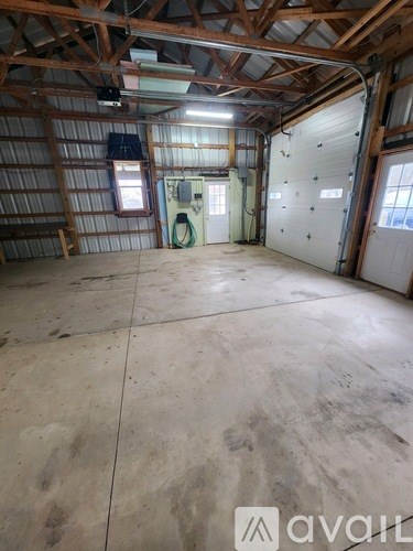 A large empty room with a concrete floor and wooden ceiling.