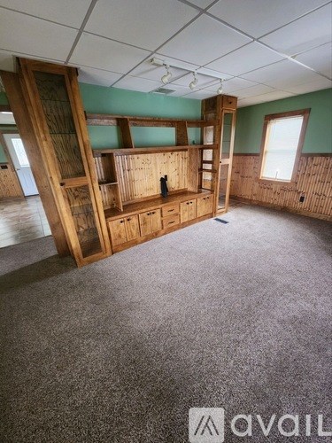 A room with wooden furniture and a carpeted floor.