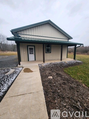 A small building with a green roof and a white door is shown.