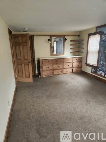 A room with a brown door and a window with blinds.
