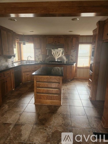 A kitchen with wooden cabinets and a black countertop.