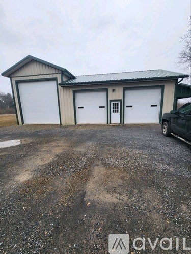 A large garage with a car parked in front.