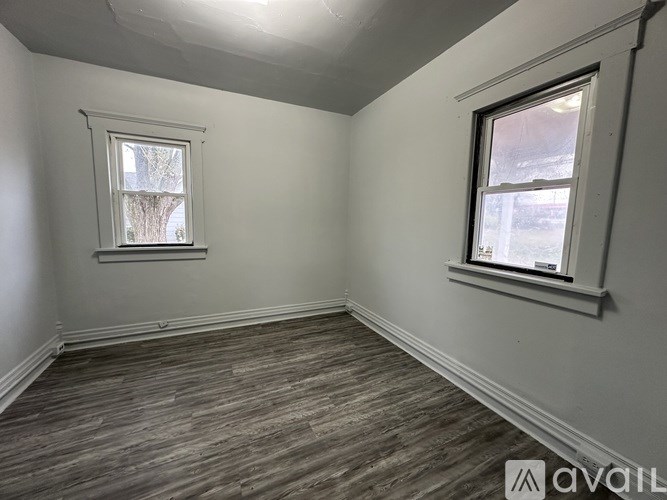 A room with a window and wooden flooring.
