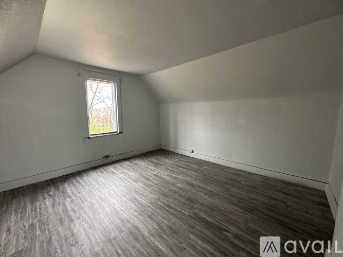 A room with wooden flooring and a window.