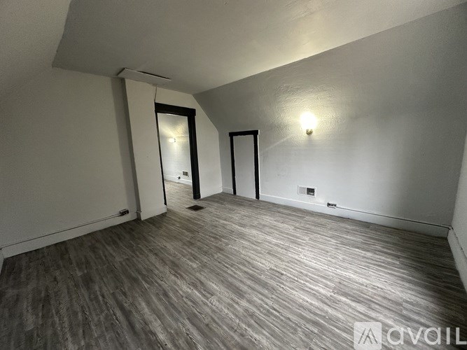 A room with wooden flooring and two doors.