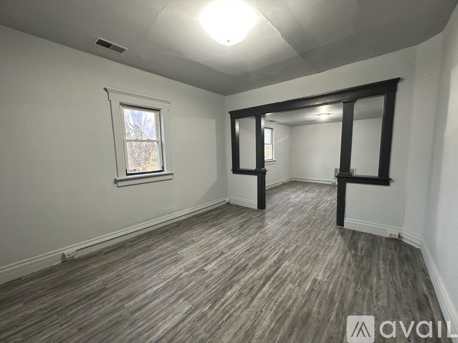 A room with wooden flooring and a window.