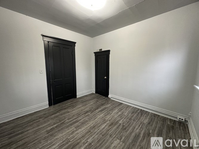 A room with two doors and a wooden floor.