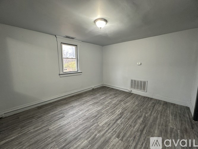 A room with wooden flooring and a window.