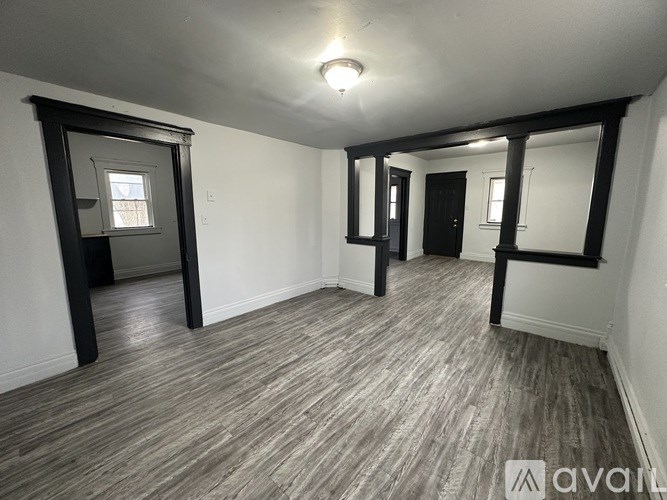 A room with wooden flooring and white walls.