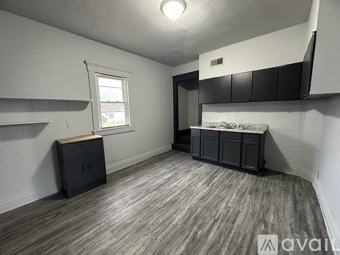 A room with wooden flooring and a window.