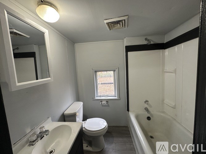A bathroom with a toilet, sink, and bathtub.