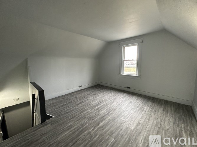 A room with wooden flooring and a window.