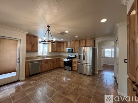 A kitchen with wooden cabinets and tile flooring.