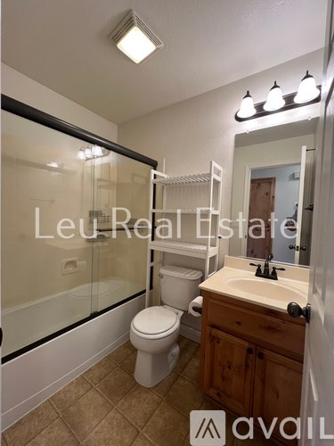 A bathroom with a toilet, sink, and shower.