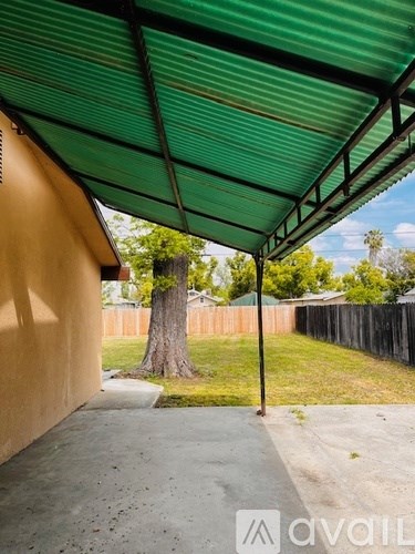 A green metal awning over a concrete patio.