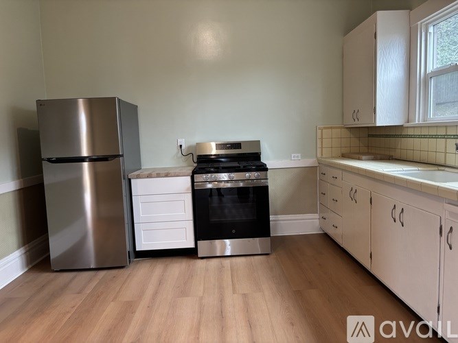 A kitchen with a stainless steel refrigerator, oven, and cabinets.