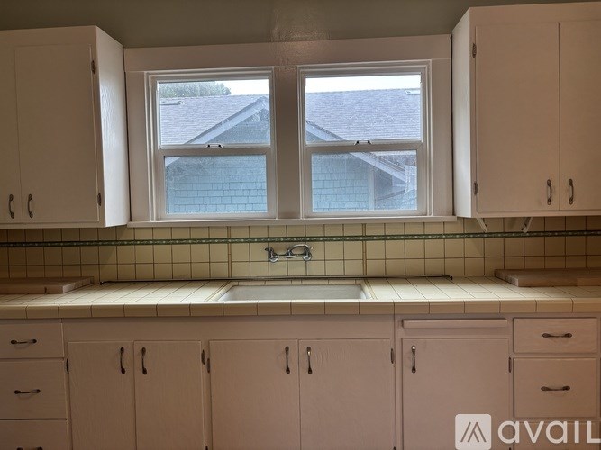 A kitchen with white cabinets and a tiled backsplash.