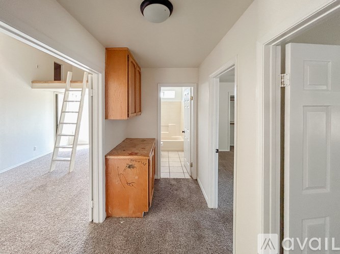 A room with a ladder and a wooden box on the floor.