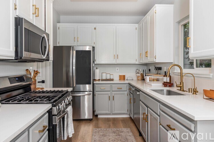 A modern kitchen with white cabinets and stainless steel appliances.