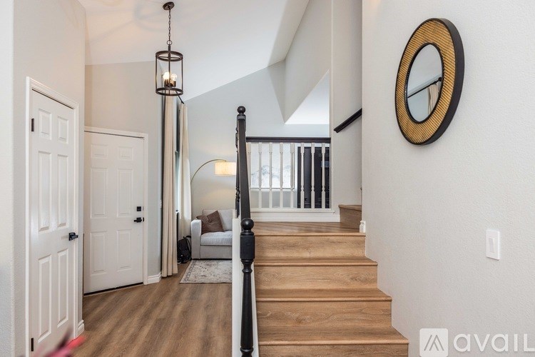 A staircase with a wooden banister and a light hanging from the ceiling.