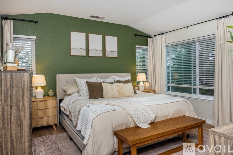 A bedroom with a bed, nightstand, and window.