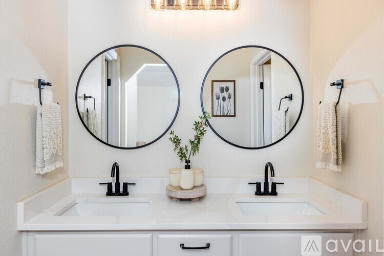 A bathroom with two sinks and two mirrors above them.