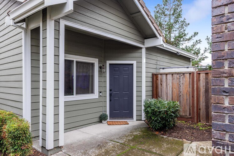 A house with a grey siding and a dark blue door.