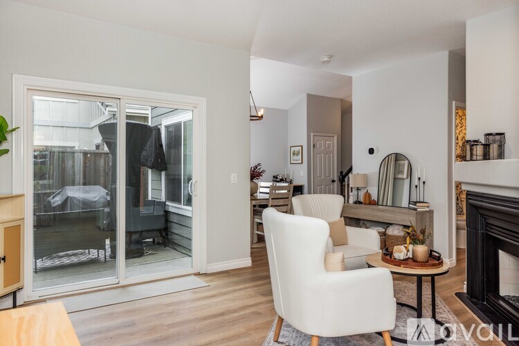 A living room with a white chair and a fireplace.