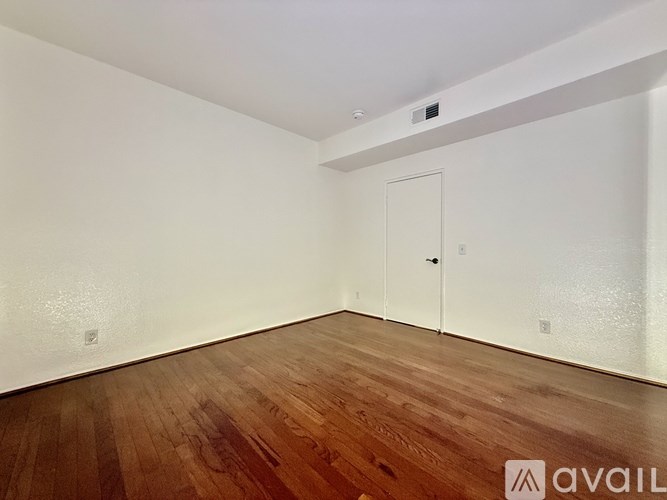 A room with wooden flooring and a white door.
