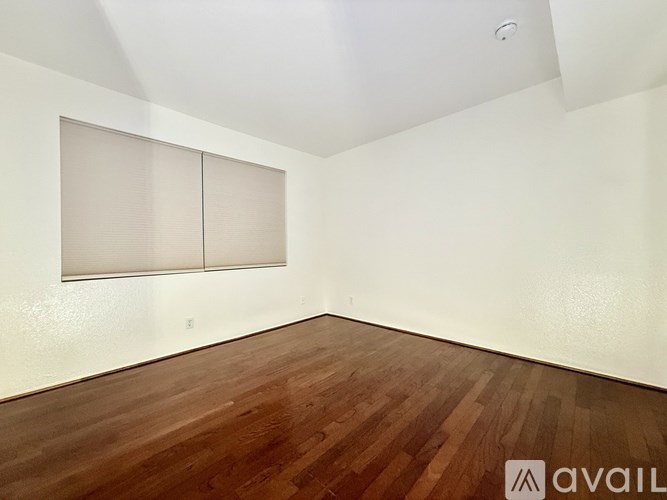 A room with wooden flooring and a wall-mounted cabinet.