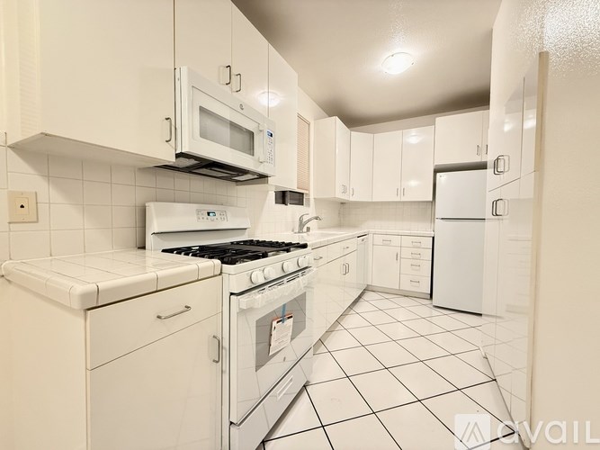 A kitchen with white appliances and cabinets.