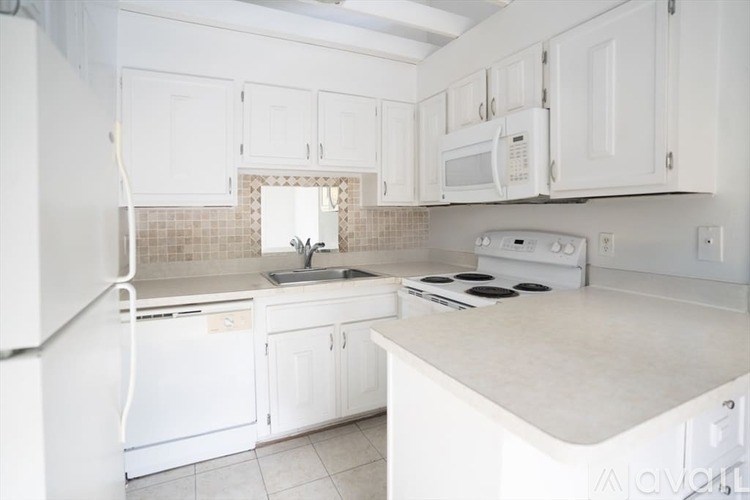 A kitchen with white appliances and cabinets.