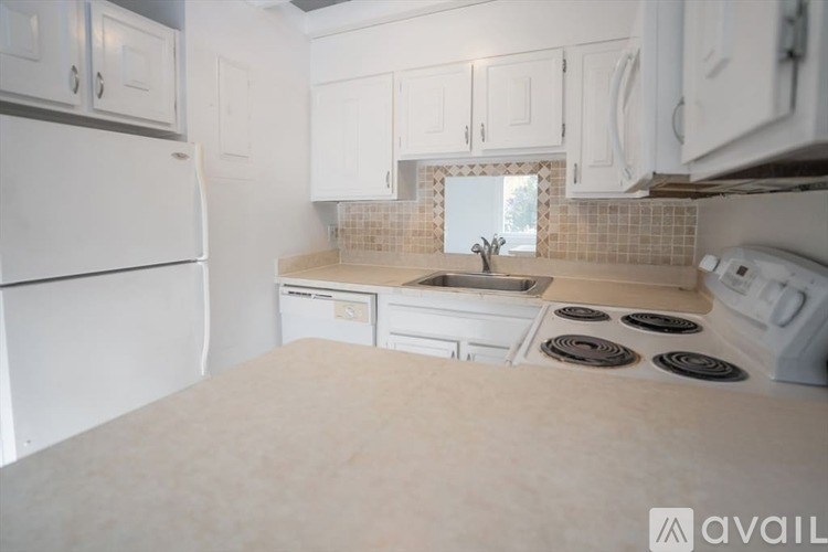 A kitchen with white appliances and cabinets.