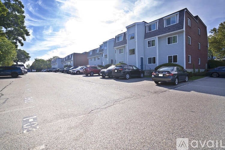 A parking lot with cars and apartment buildings in the background.