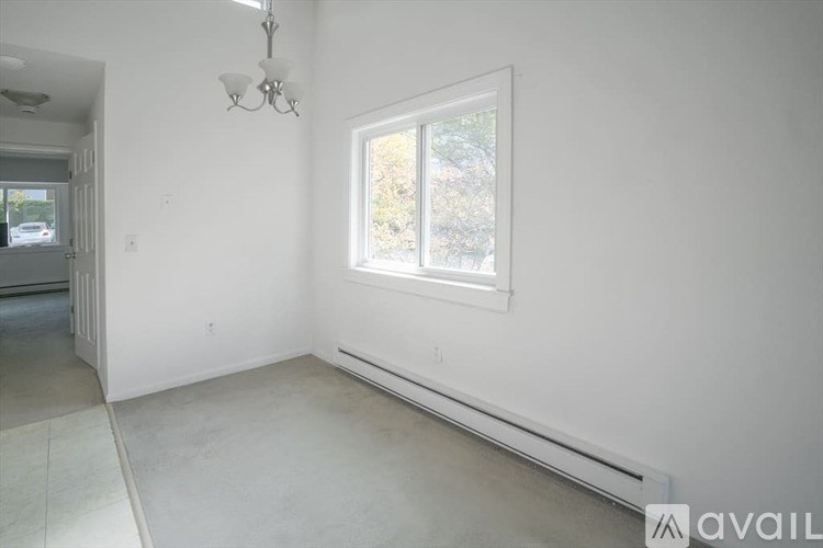 A room with a window and a chandelier.