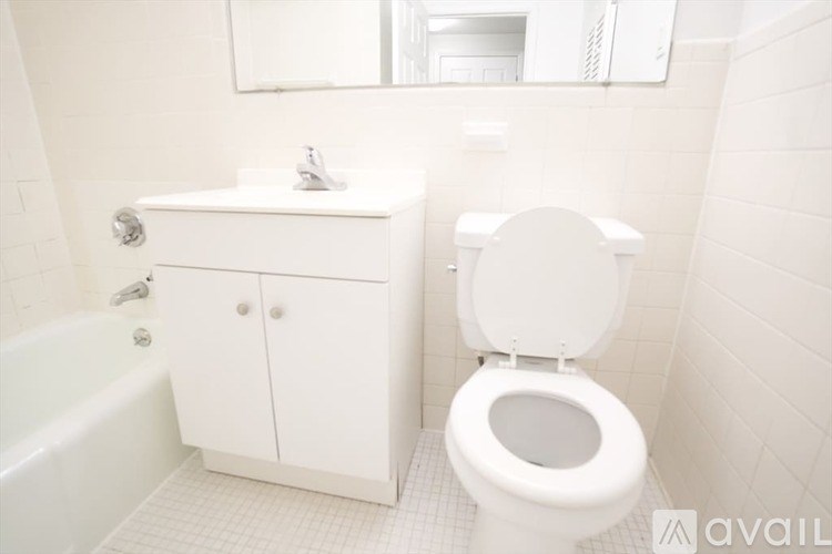 A white bathroom with a toilet, sink, and bathtub.