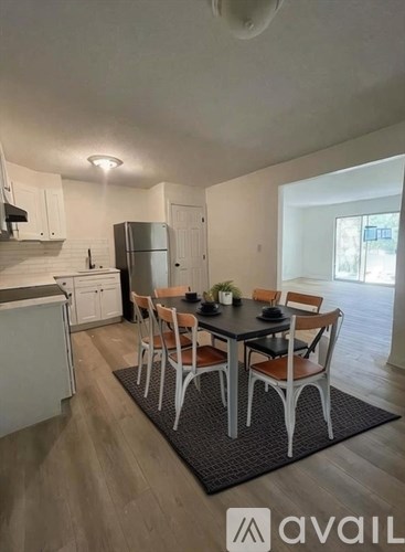A kitchen with a dining table and chairs.