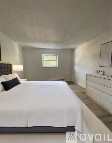 A bedroom with a large bed and a window.